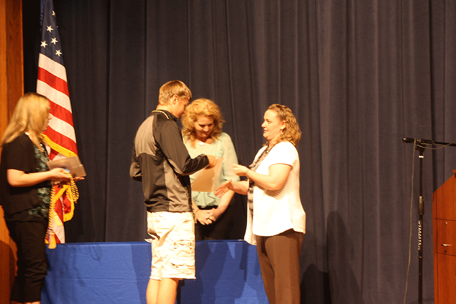 Parker Cyza receiving the quill and scroll for Journalism from Mrs. Digmann