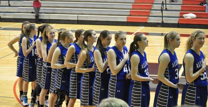AHS Girls Basketball team stands for the pledge of allegiance before a game. 